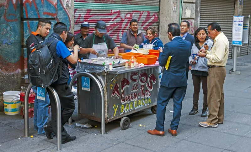 Office workers and locals gathered around a street taco cart in downtown Mexico City
